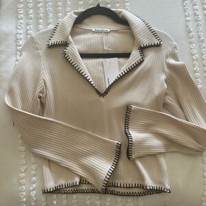 Reformation cream with black stitch top.